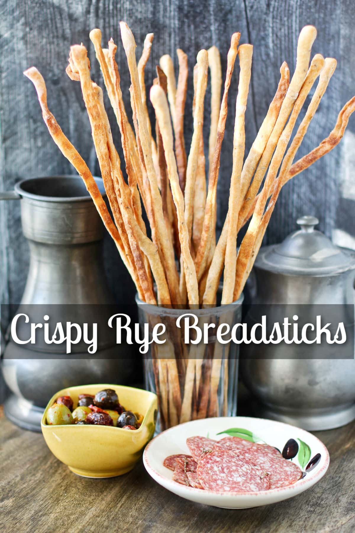 Crispy Rye and Caraway Breadsticks in a glass with charcuterie.